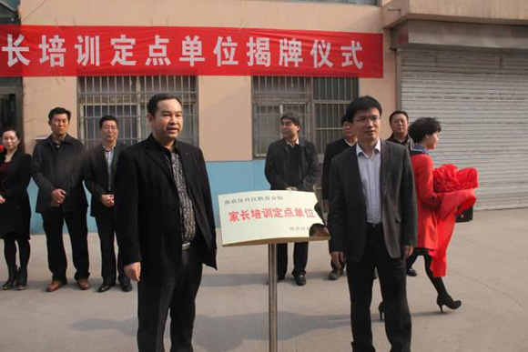  東方司樂國際教育董事長宋振寶先生（左）與張店區(qū)副區(qū)長孫宏業(yè)先生（右）共同揭牌（家長培訓(xùn)定點單位）。 